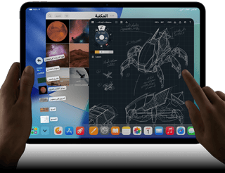 جهاز iPad Pro‏، لون أسود فلكي، يد يسرى تحمل الجهاز، يد يمنى تشير إلى الشاشة للتحكم في عدة نوافذ تطبيقات مفتوحة، تطبيق رسم مع رسومات لتصاميم ميكانيكية، مكتبة صور للكواكب والفضاء، ملفات في مجلد التنزيلات معروضة على شكل مروحة