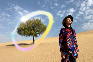 جهاز iPad Pro، الجزء الأمامي الخارجي من الشاشة مع خلفية ذات تدرّج باللونين الأزرق الداكن والأخضر تعرض عدة تطبيقات مفتوحة، يد تحمل قلم Apple Pro وتضع دائرة حول رسم يعرض ميزة عصا الصور السحرية في Apple Intelligence