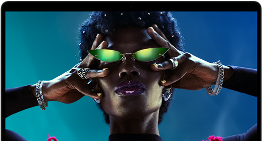 Colorful screen on a MacBook Pro of a person crowd-surfing at a party, showcasing the vibrant Liquid Retina XDR display